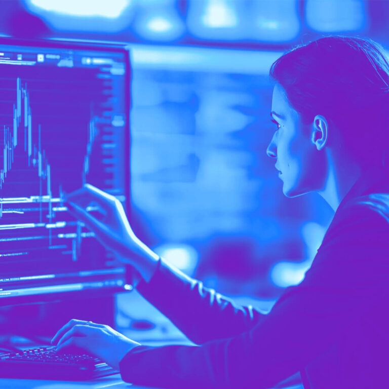 La imagen muestra a una mujer de perfil, observando con atención la pantalla de una computadora. Con una mano señala un gráfico con picos y caídas, mientras con la otra escribe en el teclado. La pantalla muestra datos y líneas que representan estadísticas o análisis financieros, enmarcados por un filtro en tonos azules y violetas que refuerza la estética tecnológica. El entorno sugiere un espacio de trabajo moderno, enfocado en análisis de datos y toma de decisiones estratégicas. La composición transmite concentración, precisión y búsqueda de oportunidades a través de la interpretación de información digital, en sintonía con el tema del marketing B2B.